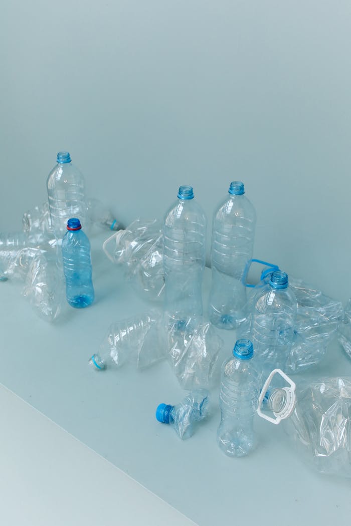 Photo of assorted empty plastic bottles on a clean, light blue surface.